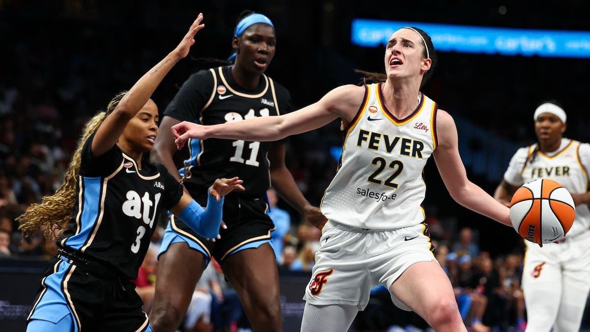 Caitlin Clark of the Indiana Fever drives to the handbasket against Jordin Canada and Madina Okot of the Atlanta Dream astatine State Farm Arena