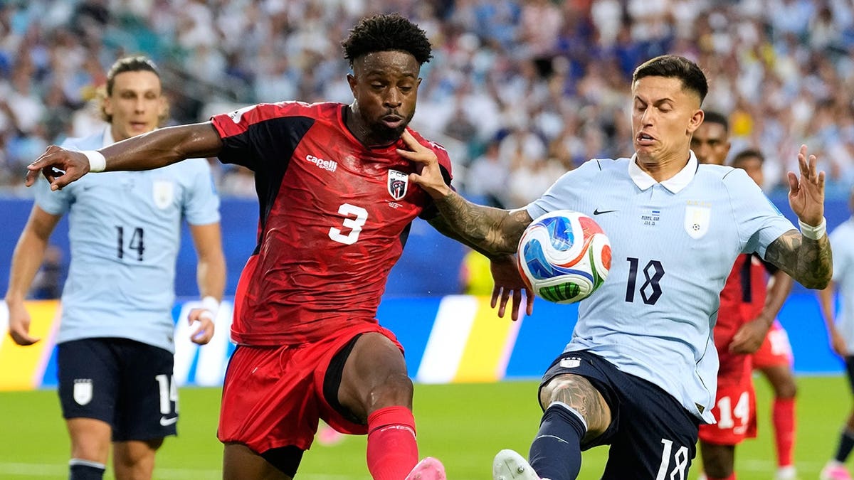 Cape Verde's Diney Borges and Uruguay's Brian Rodriguez competing for the ball in a soccer match.