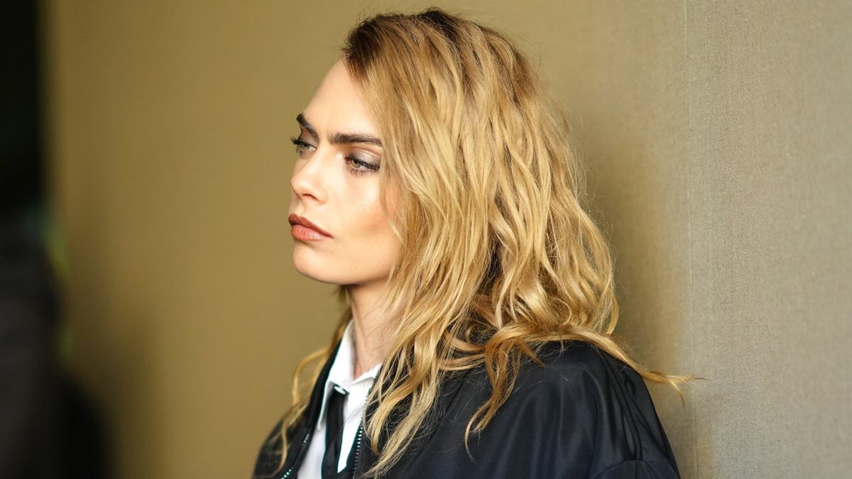 Cara Delevingne standing outside Dior during Paris Fashion Week