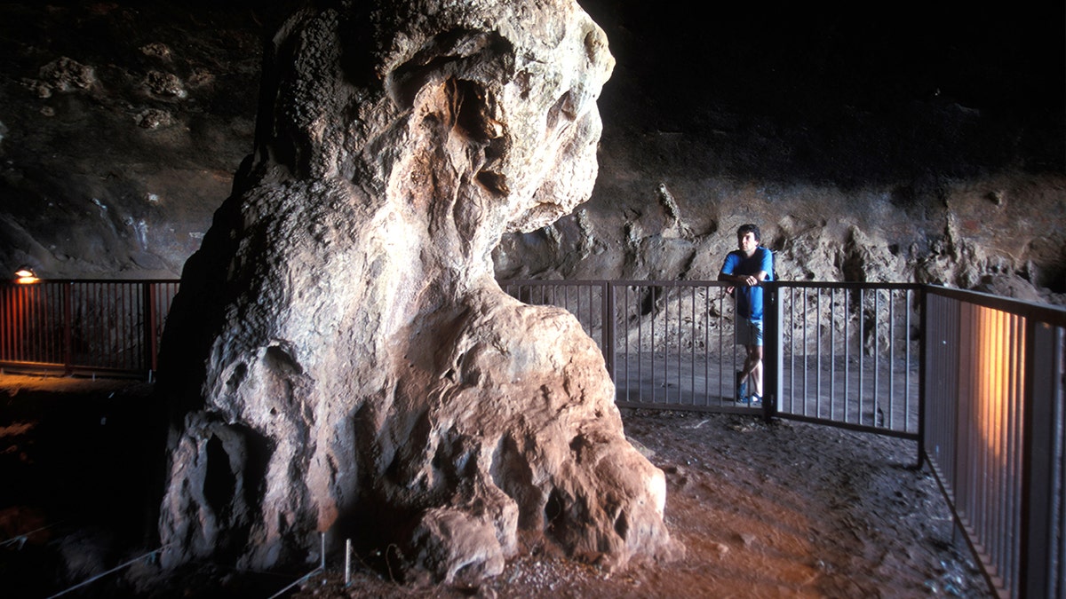 Tourist looking at structure in Wonderwerk Cave