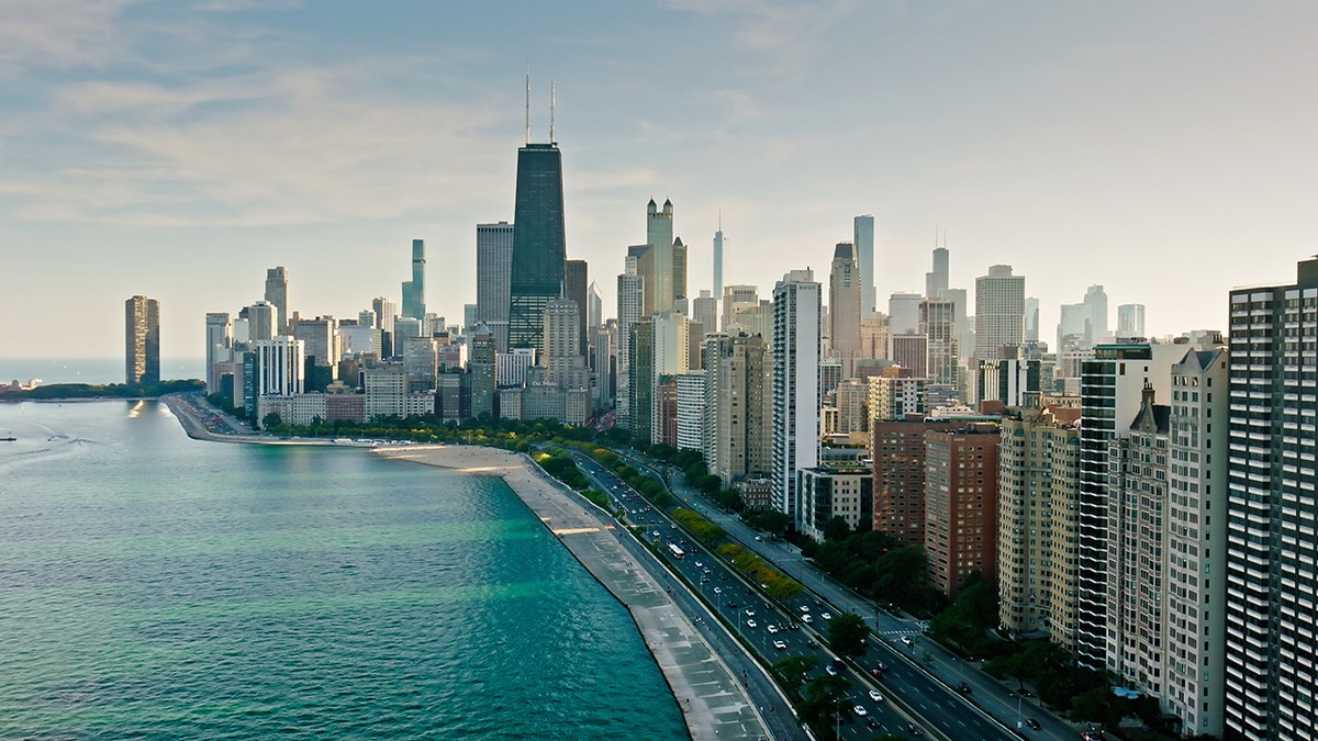 Aerial view of the Chicago skyline along Lake Michigan, featuring high-rise buildings, Lake Shore Drive, and the city’s waterfront.