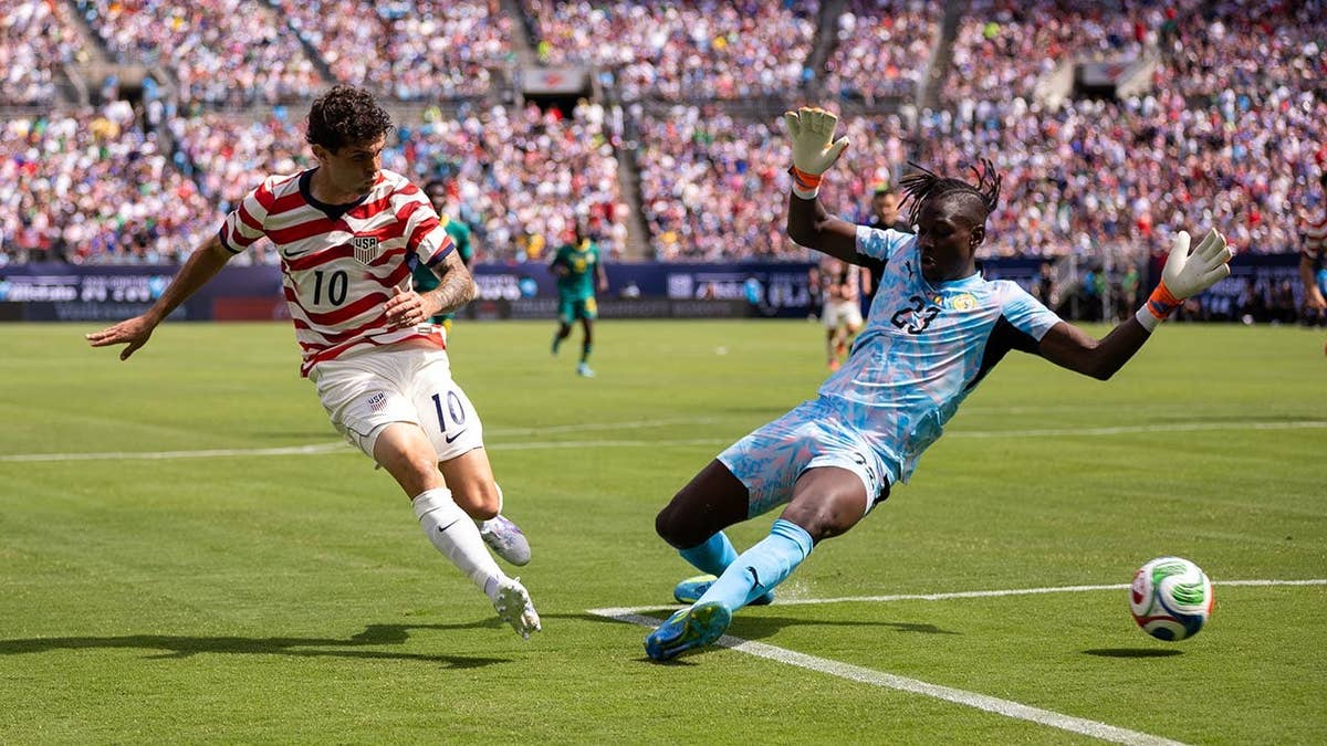 United States forward Christian Pulisic shoots past Senegal forward Cherif Ndiaye during soccer match