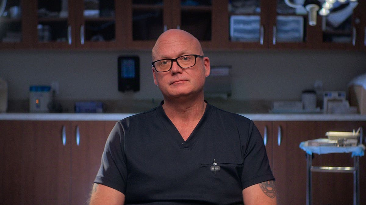 Dr. Christopher Mason sitting during an interrogation  for Maternal Instinct