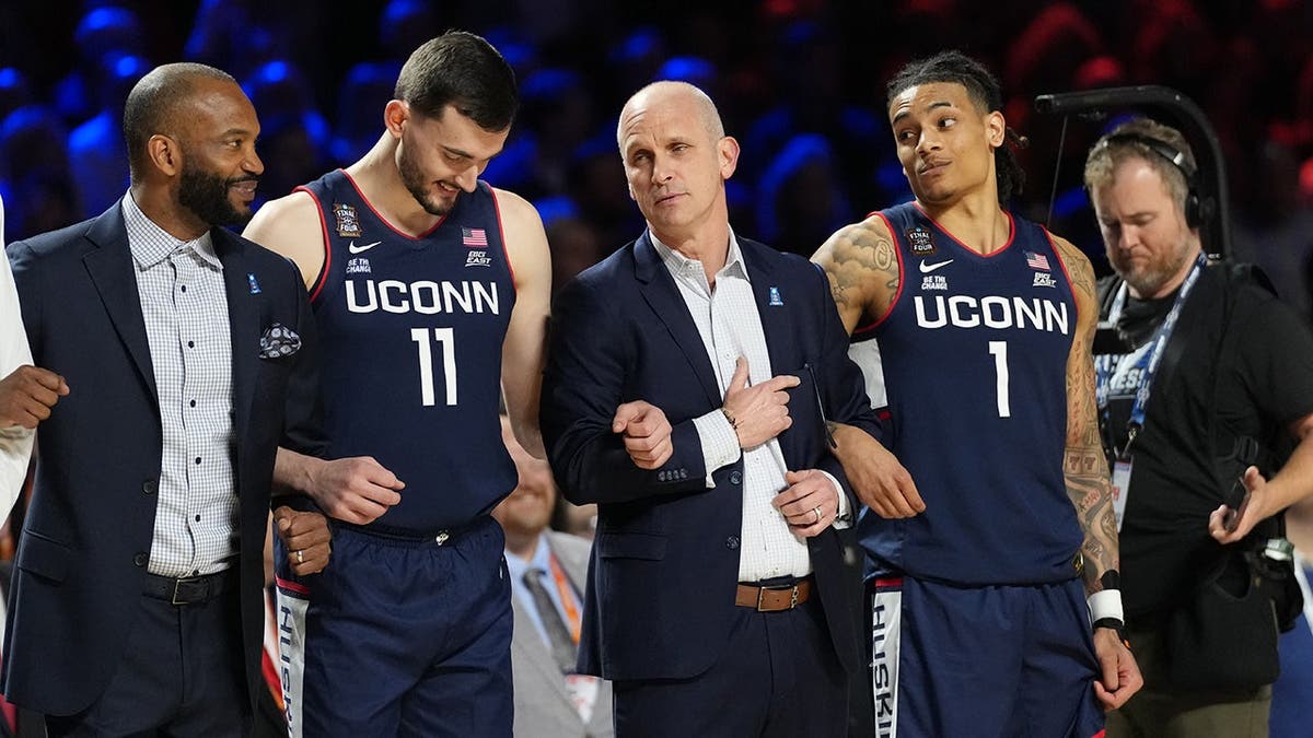 Connecticut Huskies caput manager Dan Hurley with guardant Alex Karaban and defender Solo Ball connected hoops court.