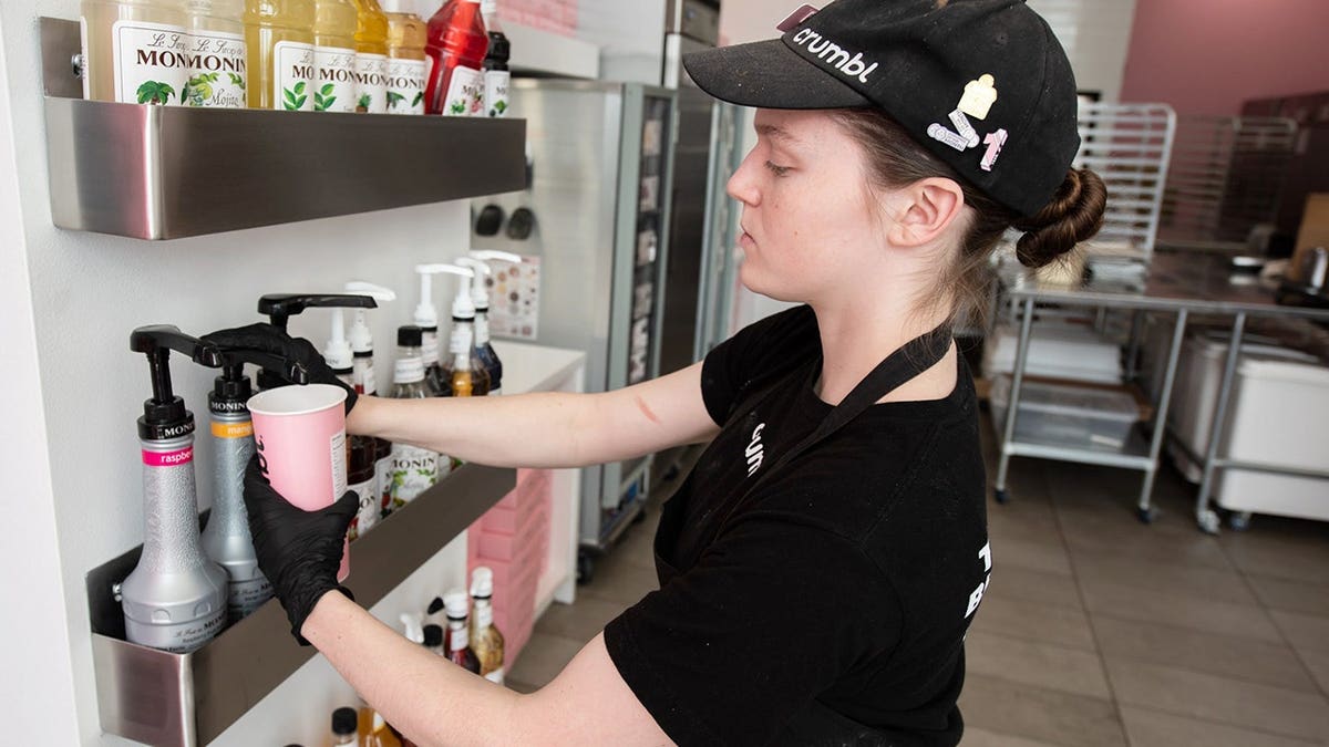 Kayleigh Crozier adding mango puree to a customized Dirty Soda astatine Crumbl successful Newtown Township