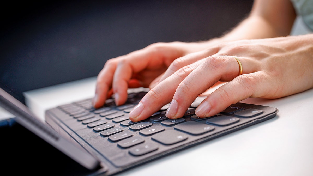 Woman typing on a keyboard.