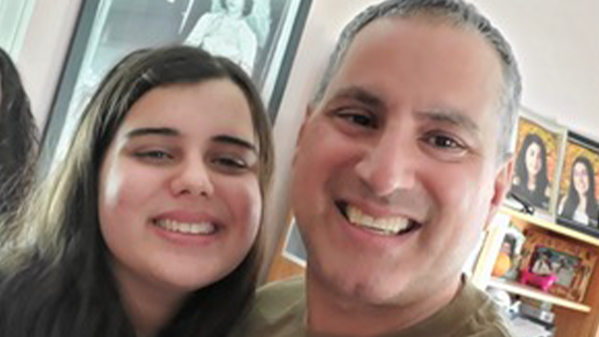 Katie Abraham (left) smiles beside her father, Joe Abraham (right), in a close-up family photograph.