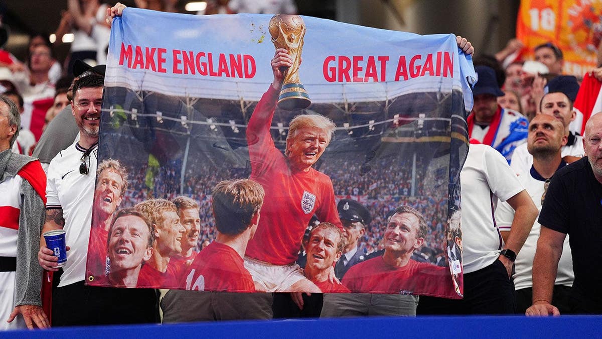 England fans holding a banner featuring Donald Trump at Dallas Stadium Arlington