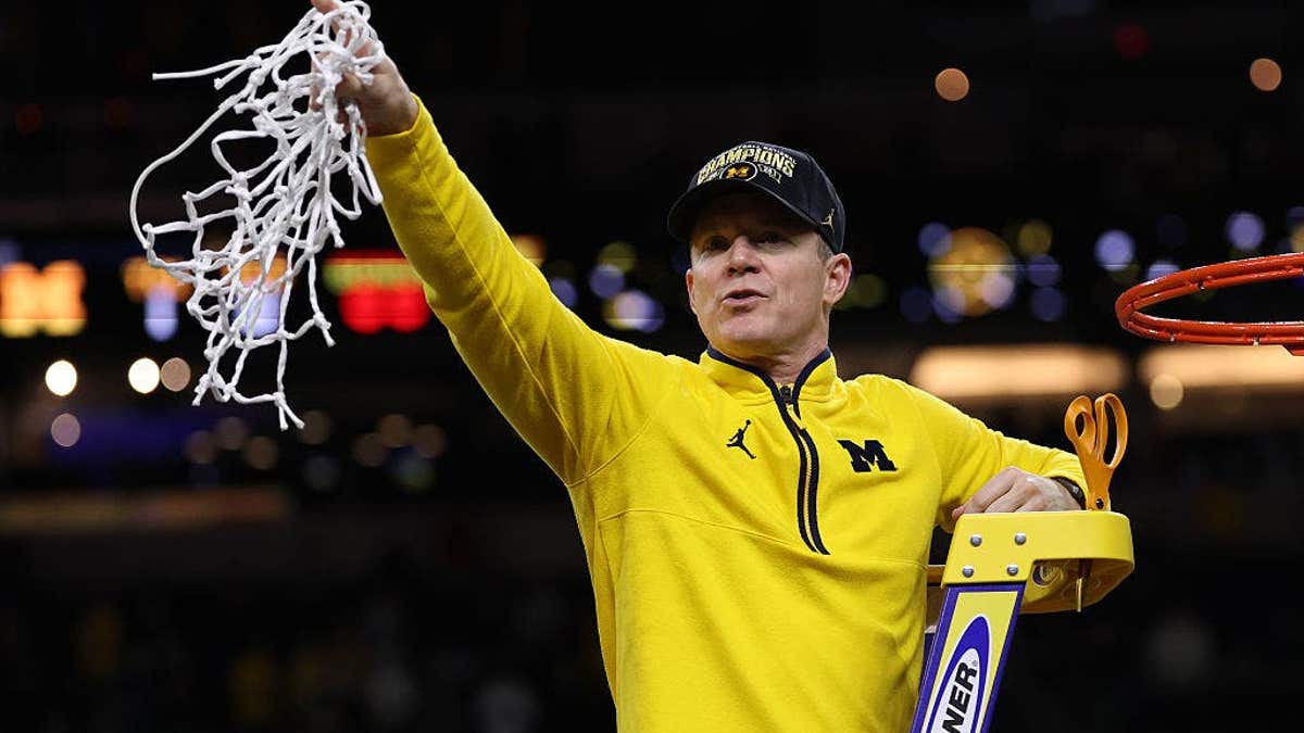 Head coach Dusty May of nan Michigan Wolverines cutting down nan nett astatine Lucas Oil Stadium successful Indianapolis