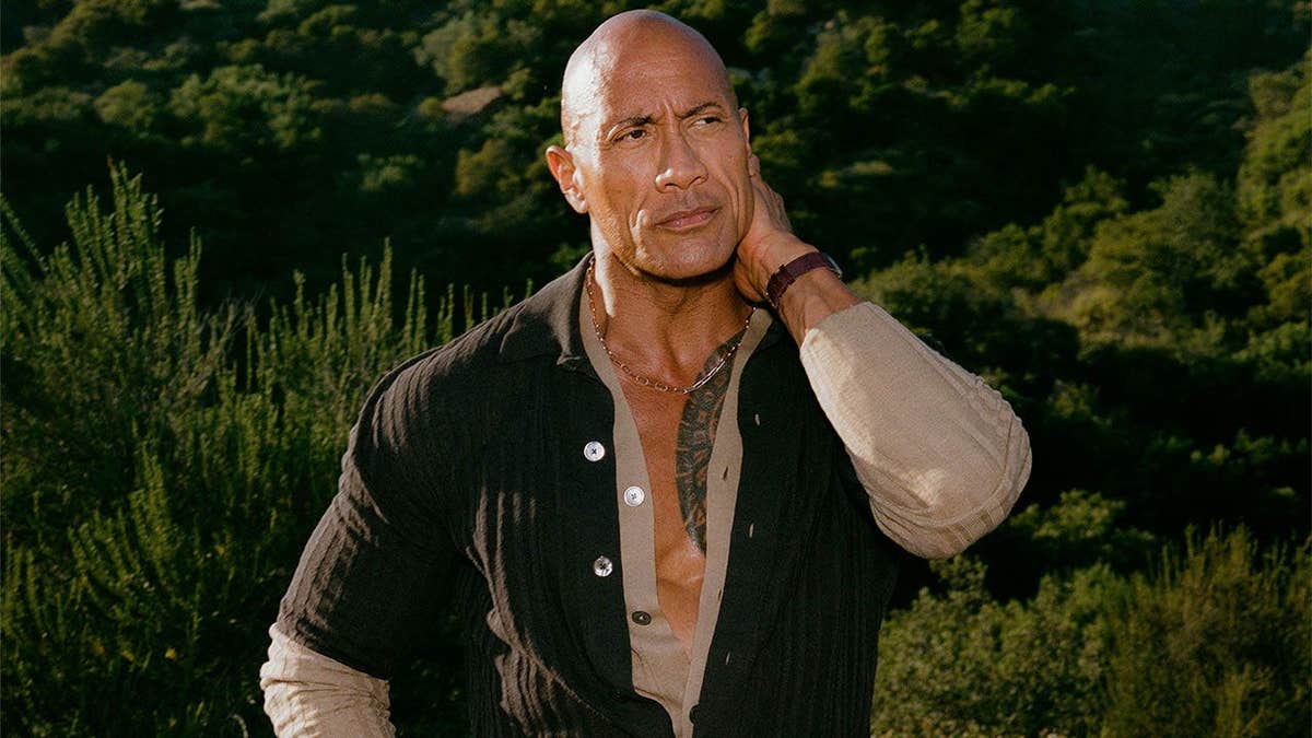 Dwayne Johnson poses near a mountain