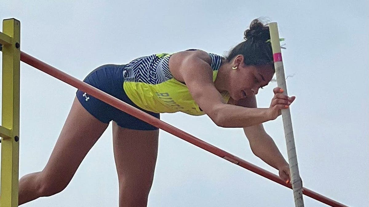 Eva Moran jumping on the pole vault bar at Jesse Owens Memorial Stadium