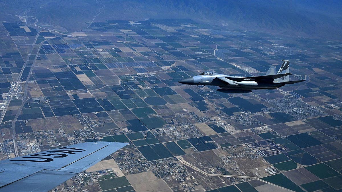 Um F-15 voando ao lado de um Boeing KC-135 Stratotanker realizando reabastecimento simulado perto da Base Aérea de March