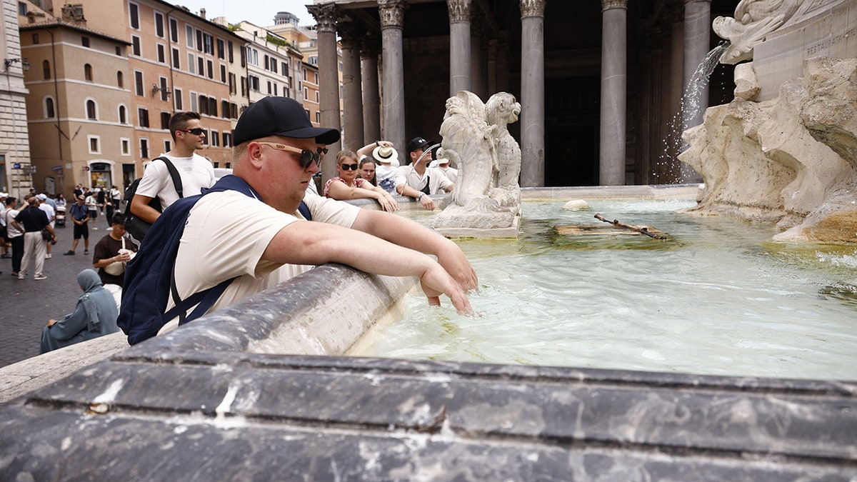 Tourist successful  Rome dips hands successful  fountain