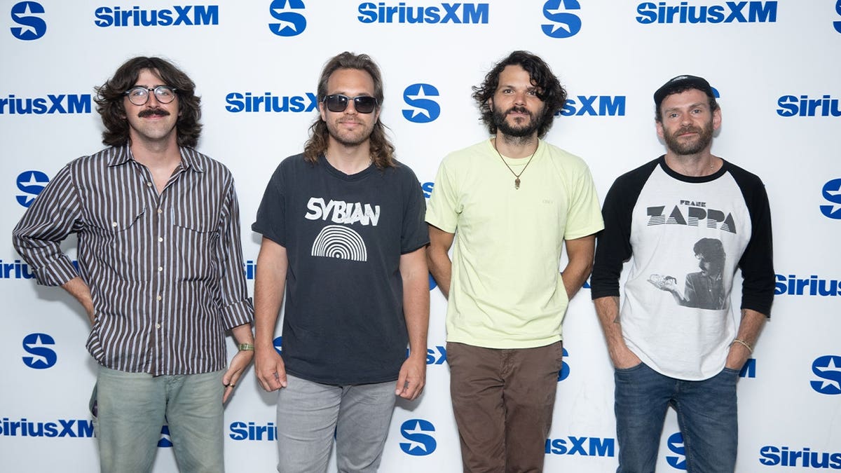 Quatro membros da banda lado a lado.