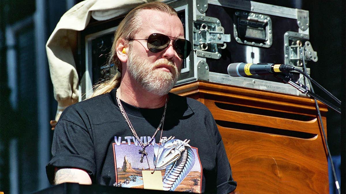 Gregg Allman of The Allman Brothers Band standing and singing