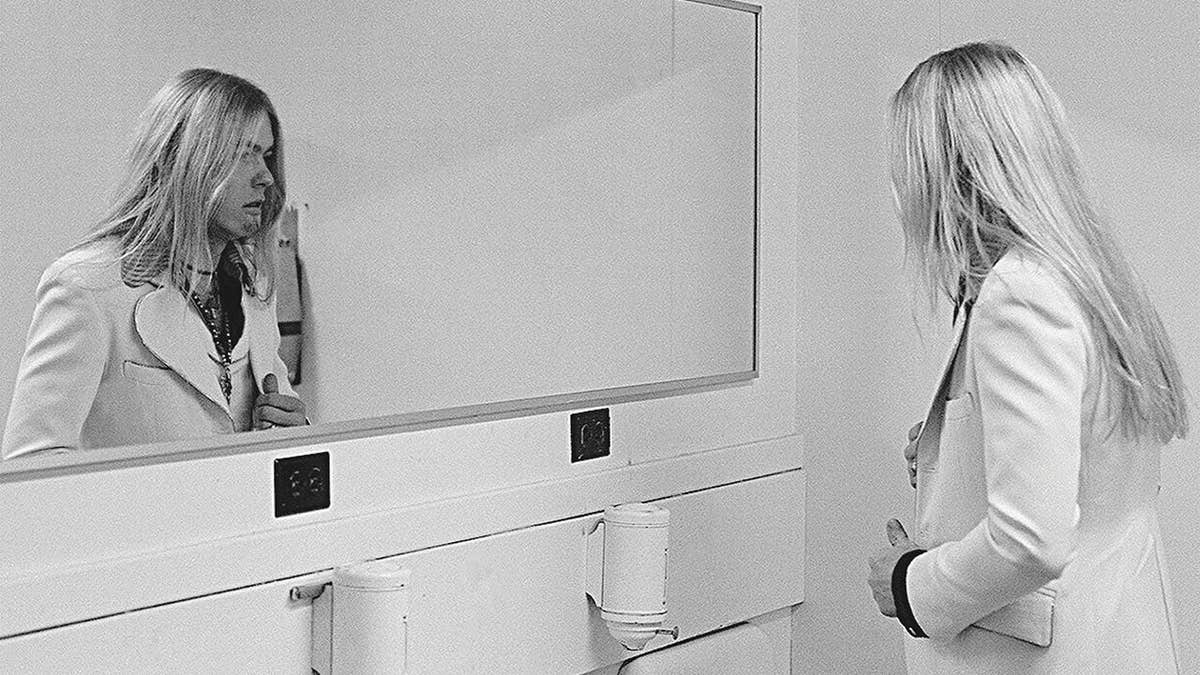 A photo of Gregg Allman looking in a mirror