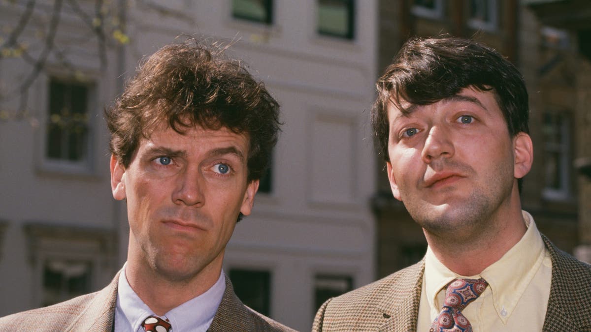 English actors Hugh Laurie and Stephen Fry standing together.