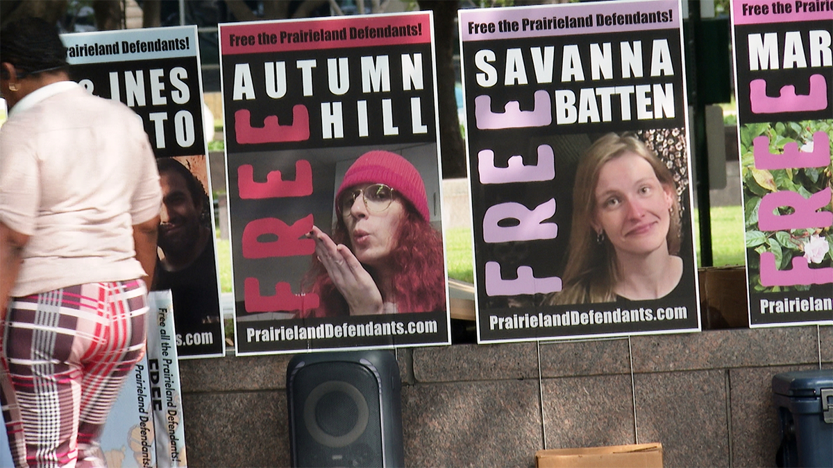 Supporters of protesters convicted over a shooting outside a Texas immigration detention center display signs.