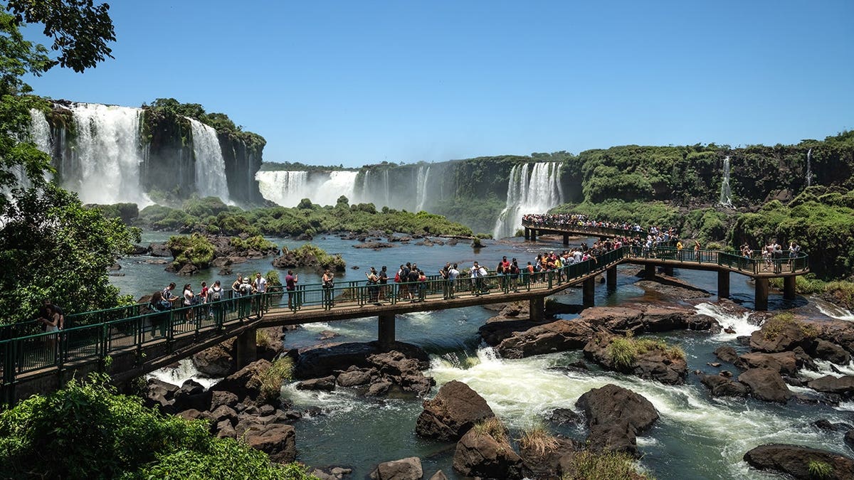 Tourists walking on footbridges overlooking Iguazu Falls in Foz do Iguaçu Brazil