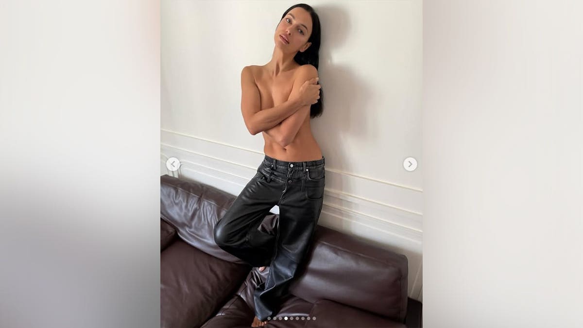 Irina Shayk posing topless while in black pants on Instagram in June 2026.