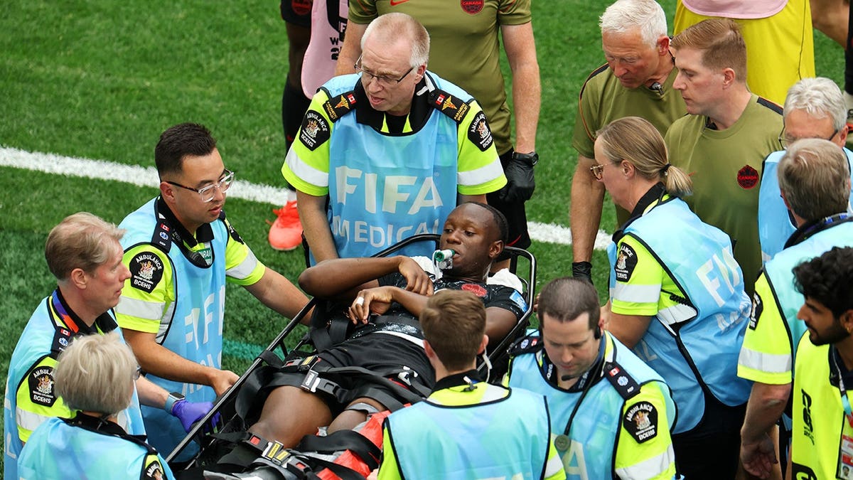 Ismael Kone of Canada stretched off after being fouled by Assim Madibo of Qatar during soccer match