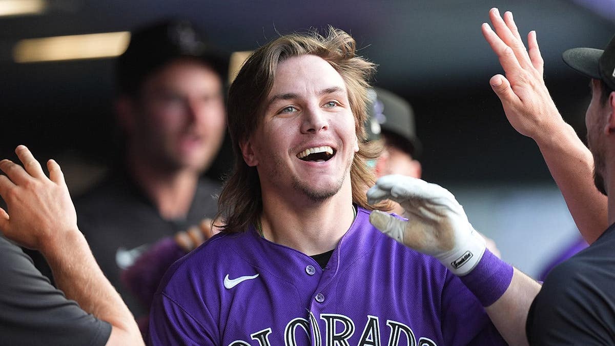 Colorado Rockies' Jake McCarthy returning to dugout aft inside-the-park location run.