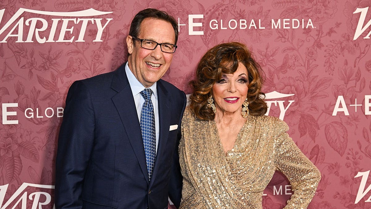 Percy Gibson and Joan Collins pose together at an event in London