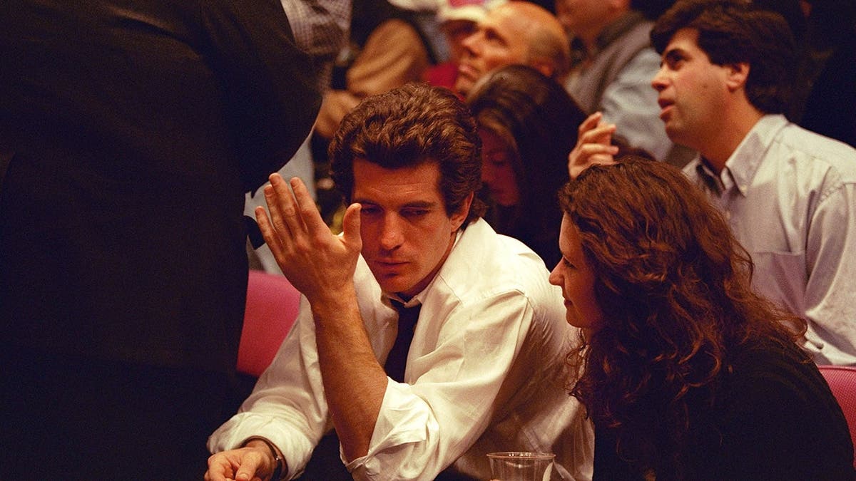 John F. Kennedy Jr. and RoseMarie Terenzio seated at Madison Square Garden during a Knicks vs Bulls game
