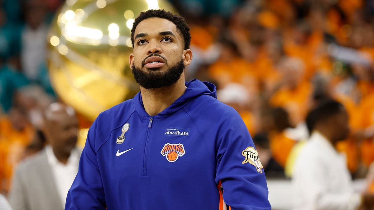 New York Knicks center Karl-Anthony Towns practicing on basketball court.
