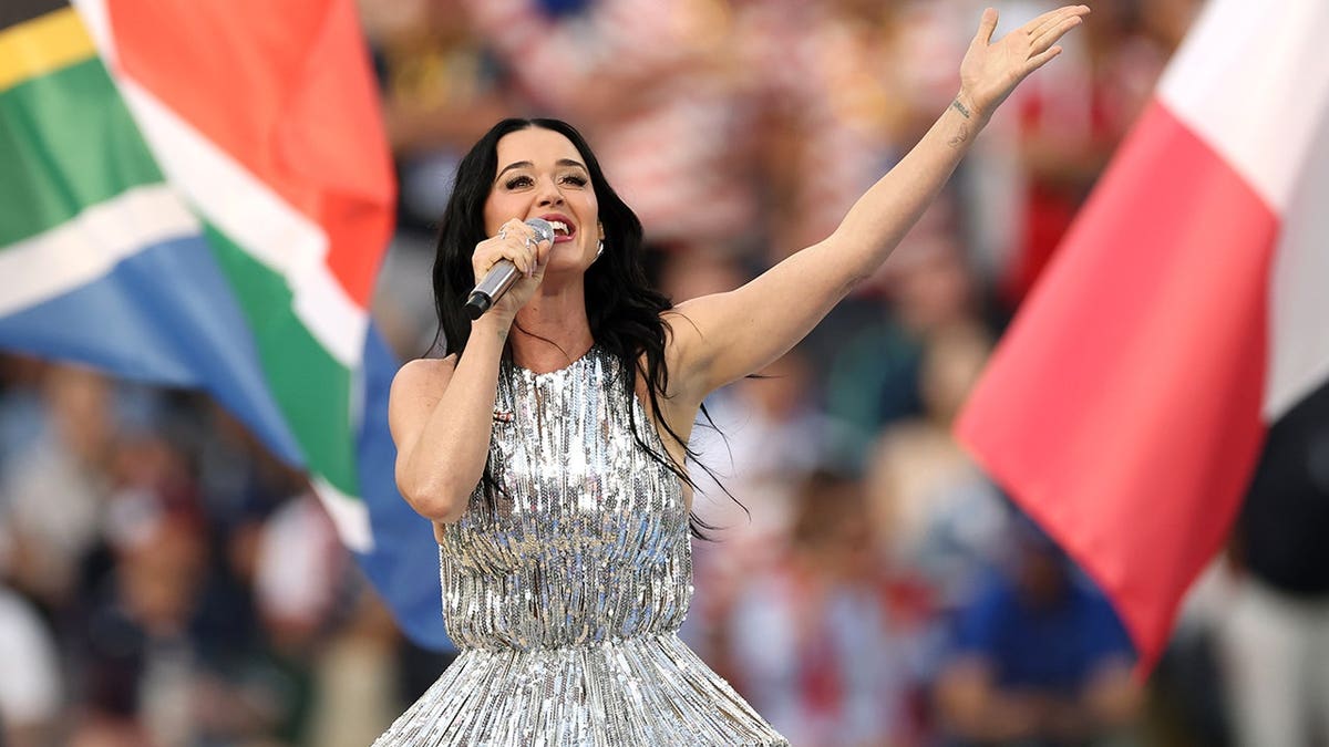Katy Perry em um vestido prateado cantando na Copa do Mundo FIFA de 2026, no jogo EUA x Paraguai, em junho de 2026.