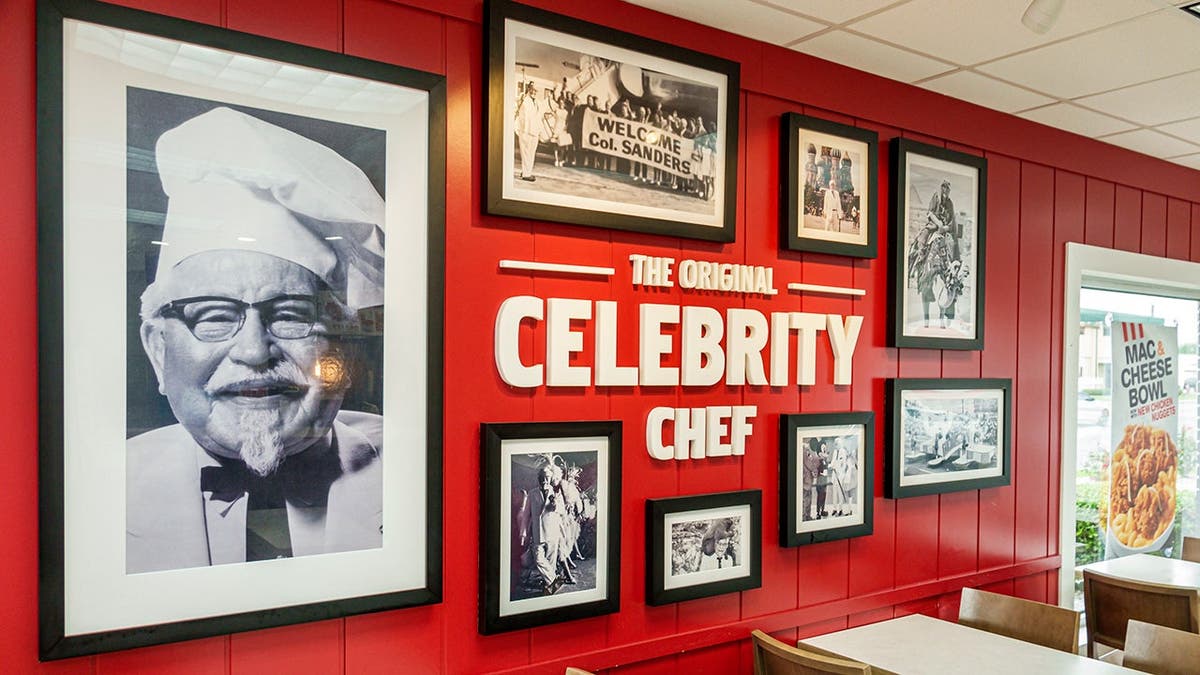 Uma parede com fotos da história do KFC.