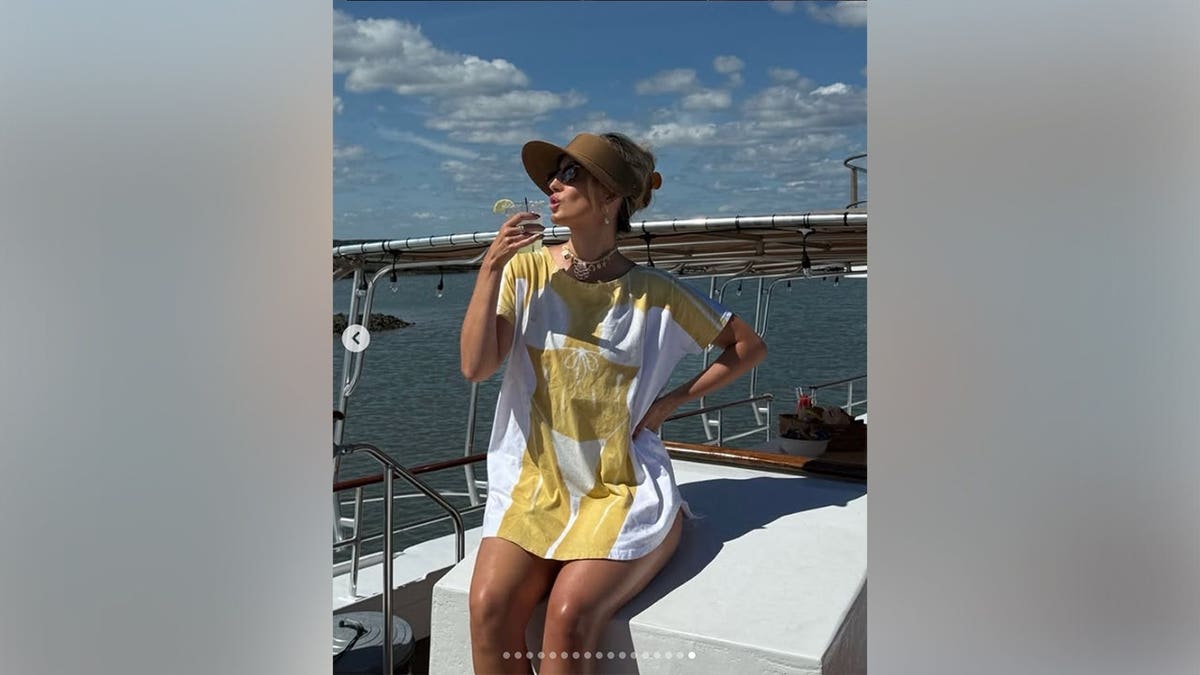 Lainey Wilson is sitting on a boat and drinking a cocktail.