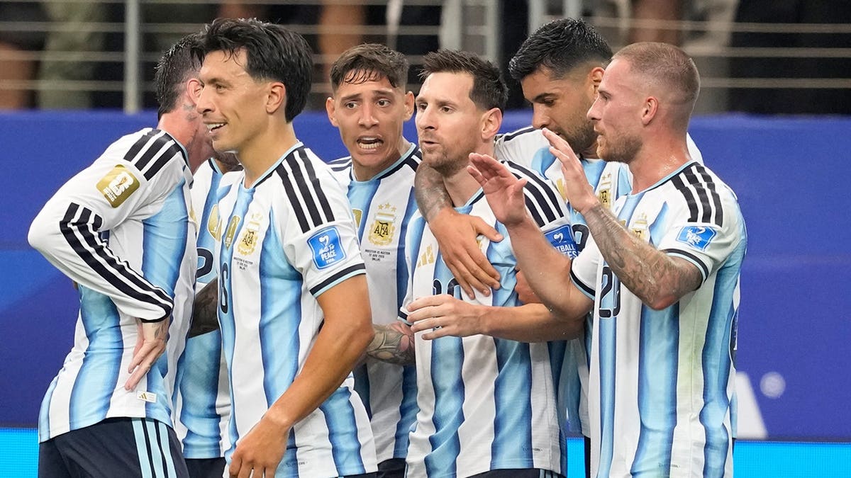 Argentina's Lionel Messi celebrating with teammates after scoring a goal in a soccer match.