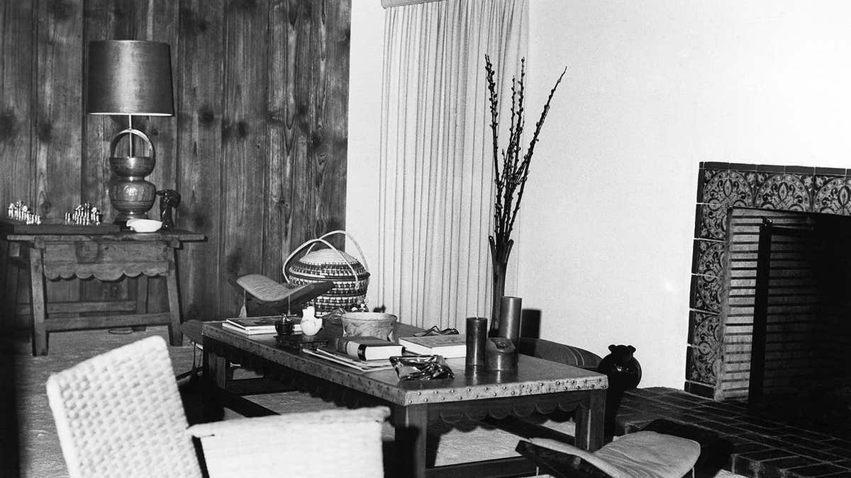 Marilyn Monroe sitting in a living room with furniture and decorations.
