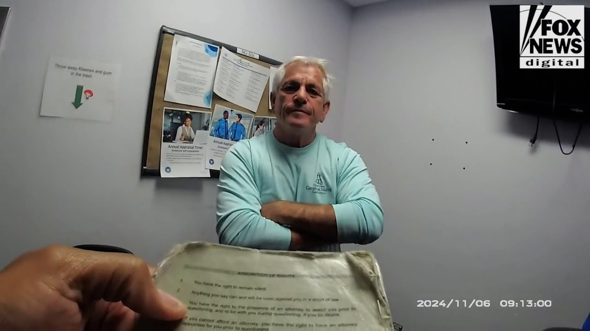 Chris Nanos has his arms crossed, wearing a agelong sleeve, airy bluish shirt