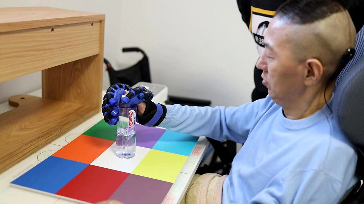 A patient uses a brain implant to control a prosthetic hand.