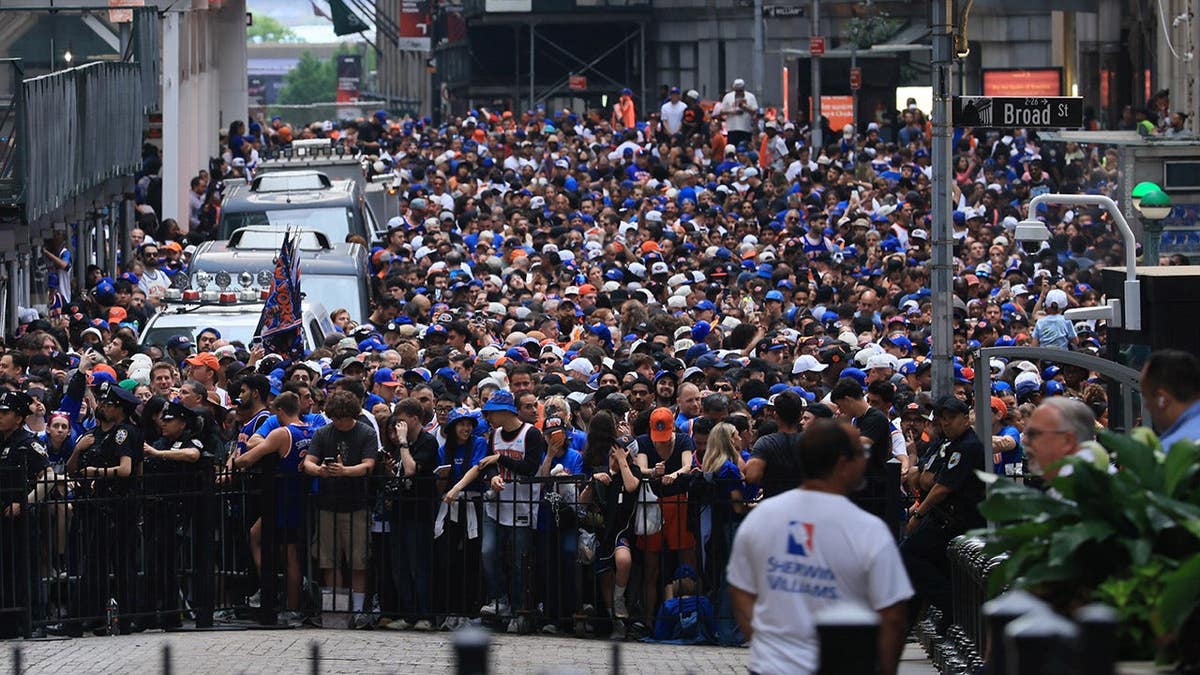 Thousands of fans crowd near Wall Street in lower Manhattan for New York Knicks championship parade.