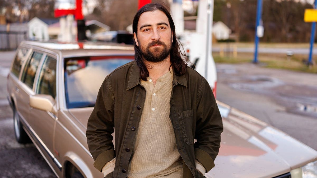 Noah Kahan posa em carroça marrom