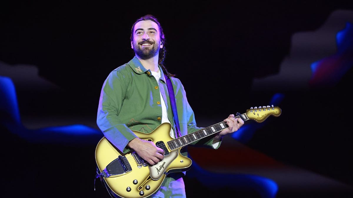 Noah Kahan segura guitarra no palco