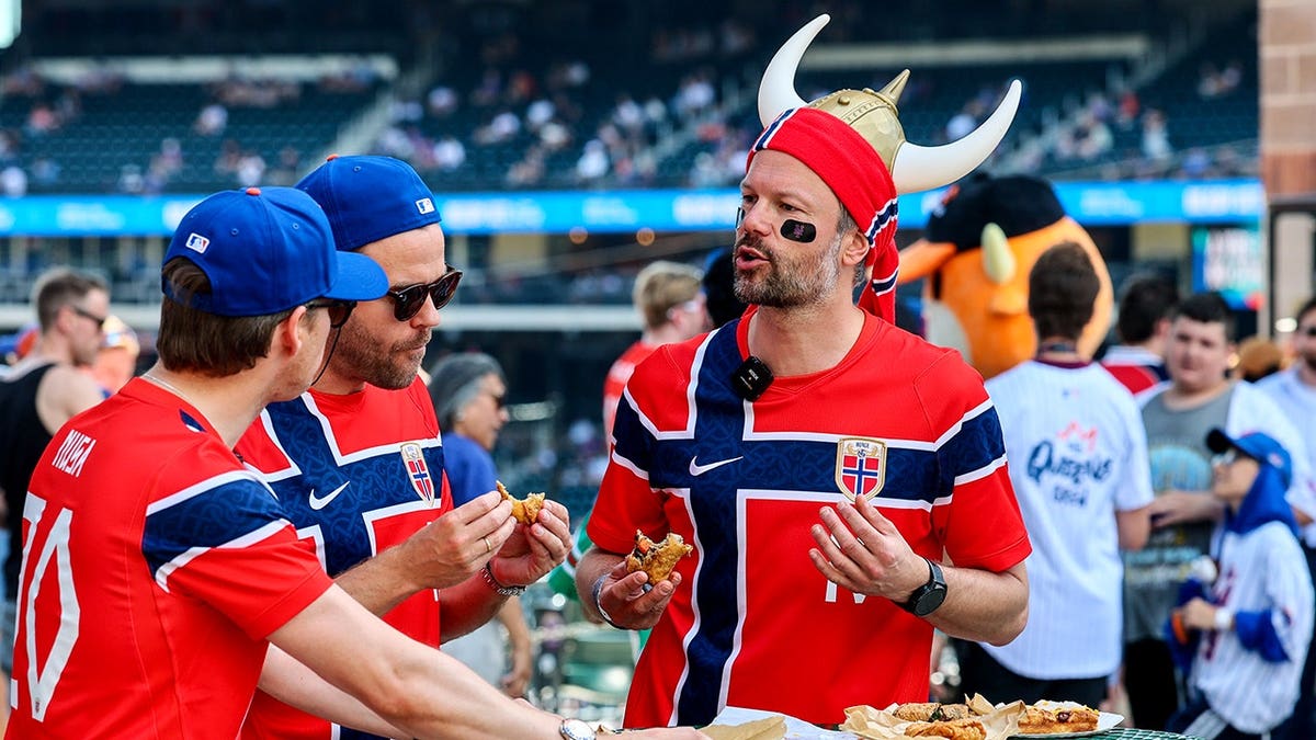 Norway national soccer team fans sampling food at Citi Field during an MLB game.