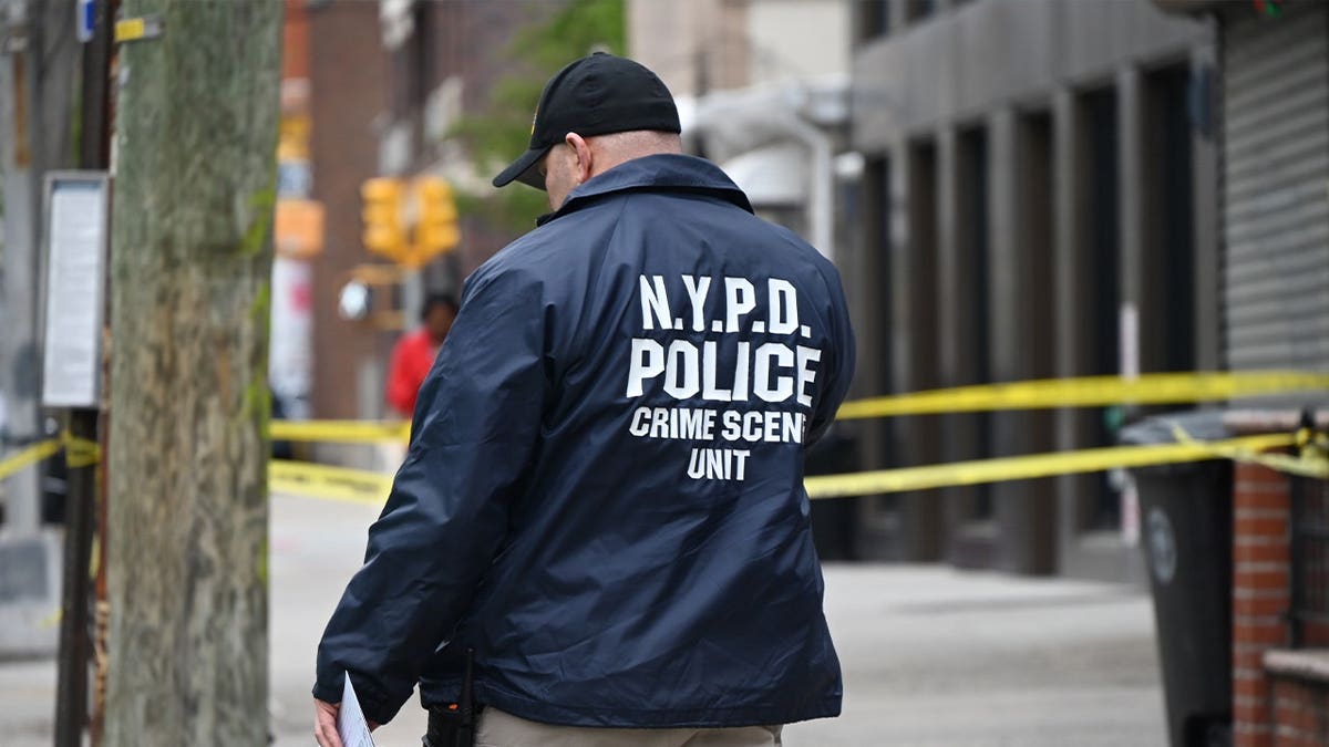 NYPD officer walks through crime scene