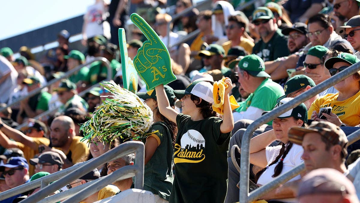 Fans cheering on the Oakland Athletics during a game at the Oakland Coliseum.