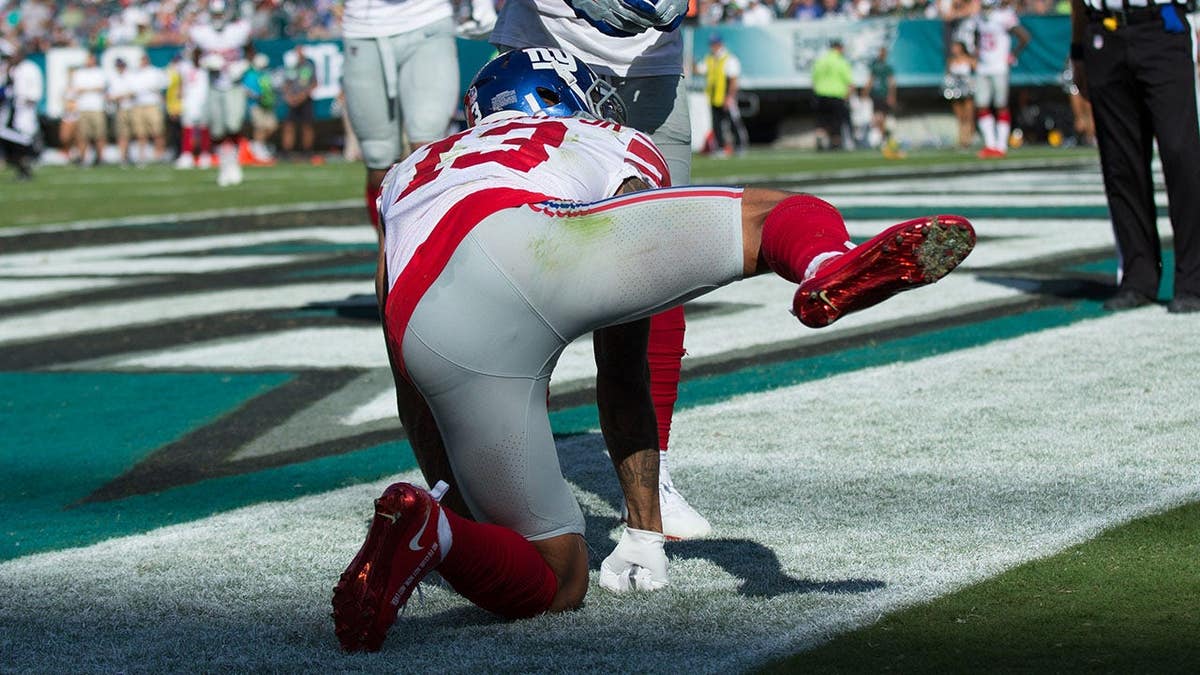 New York Giants wide receiver Odell Beckham gestures after scoring a touchdown on the field.