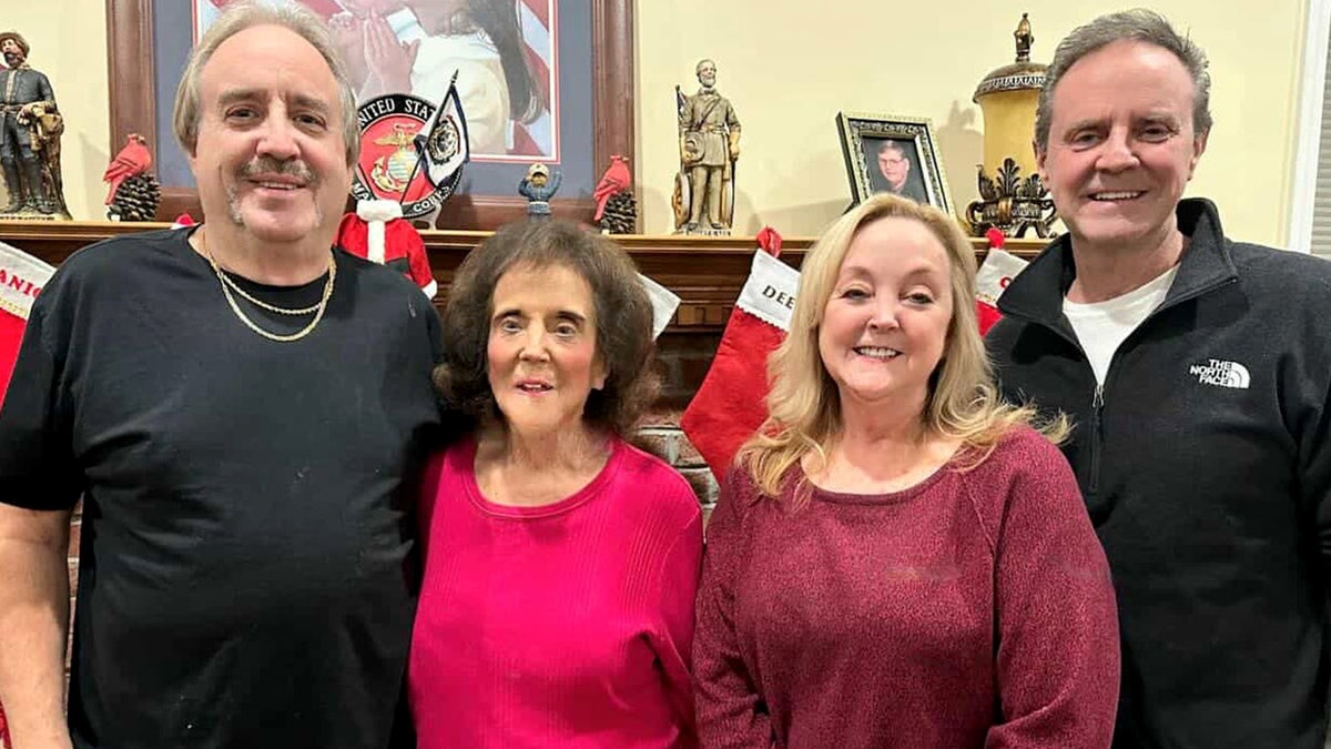 Pauline Monk stands in a photo with family members
