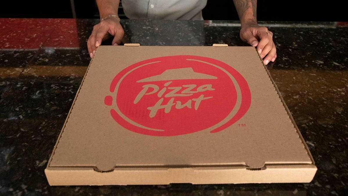 Pizza Hut employee holding a pizza box inside a store in Caracas Venezuela