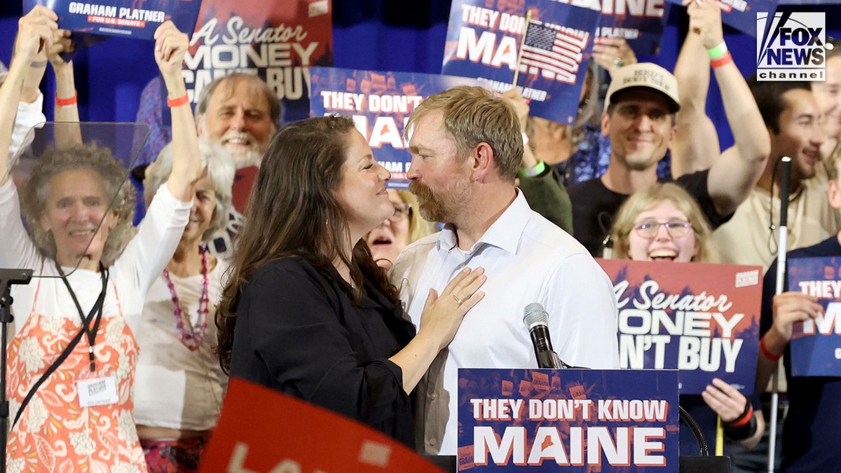 Graham Platner and Amy Gertner embrace each other while at a Senate Democratic watch party event.