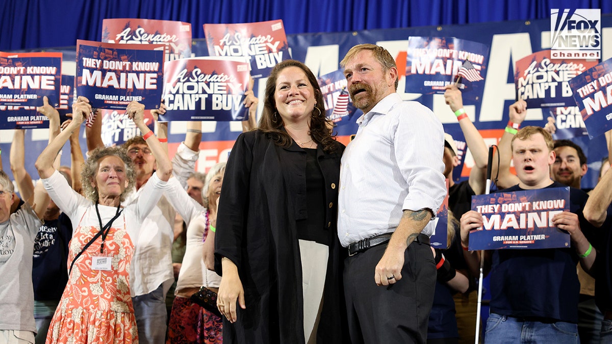Graham Platner and Amy Gertner look and smile while at a Senate Democratic watch party event.