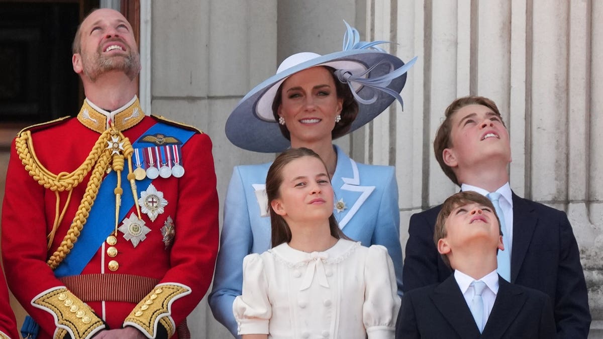 Prince William and Kate, Princess of Wales, with their children watching RAF planes flypast from Buckingham Palace balcony.
