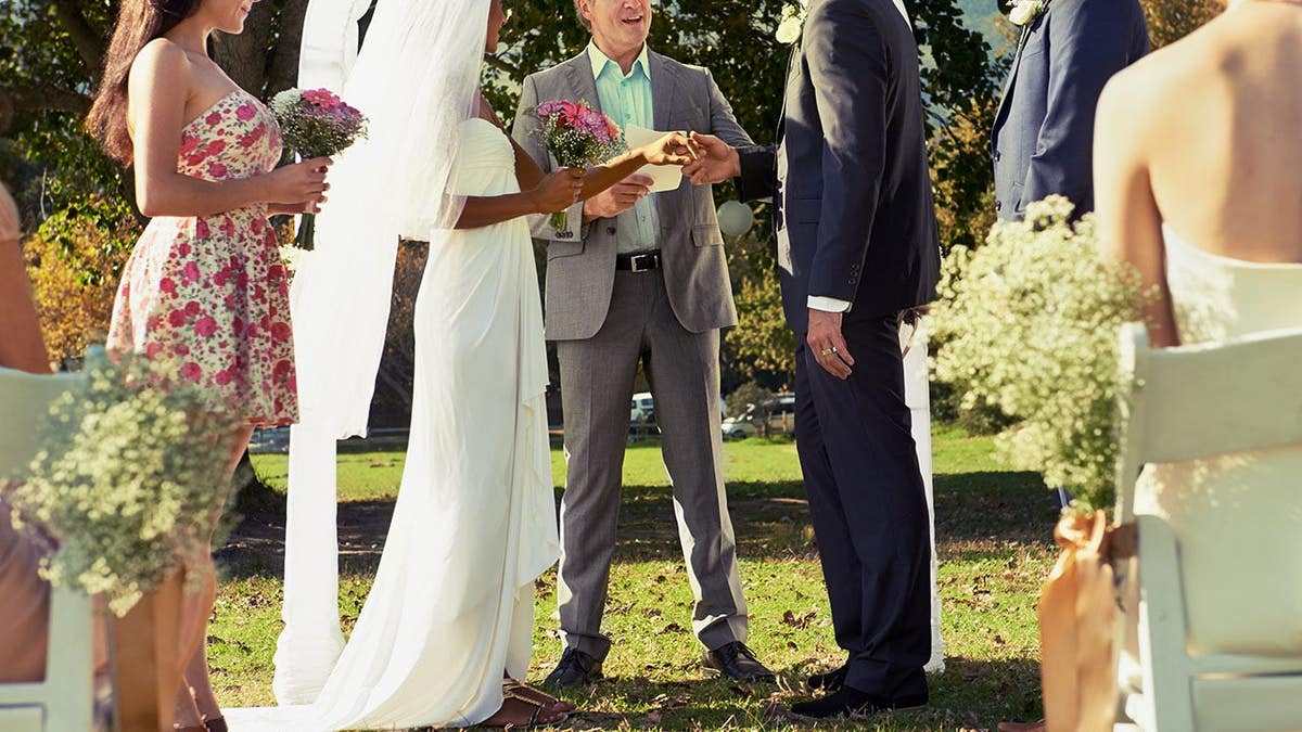 A private outdoor wedding ceremony setup with chairs and floral decorations.