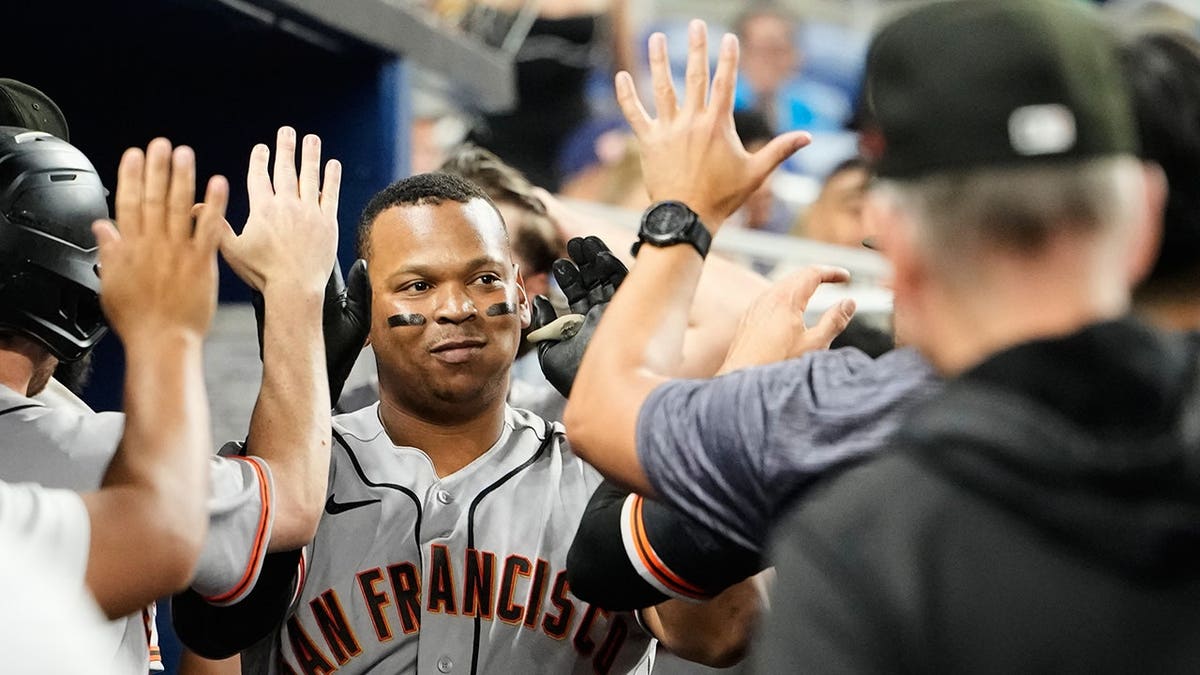 San Francisco Giants' Rafael Devers celebrating in the dugout after hitting a home run.